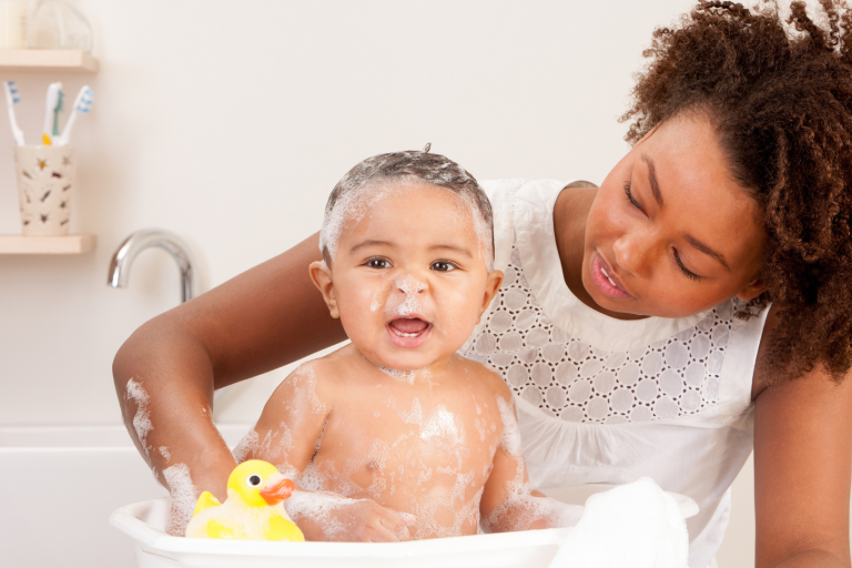 Baby in baby bath with supporting it