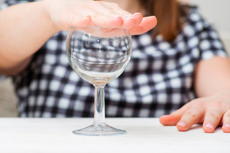 lady with hand over wine glass