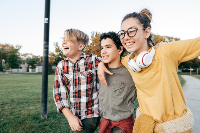 three teenagers walking arm in arm