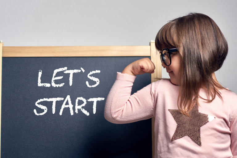 young girl showing clenching arm muscle with sign behind reading let's start