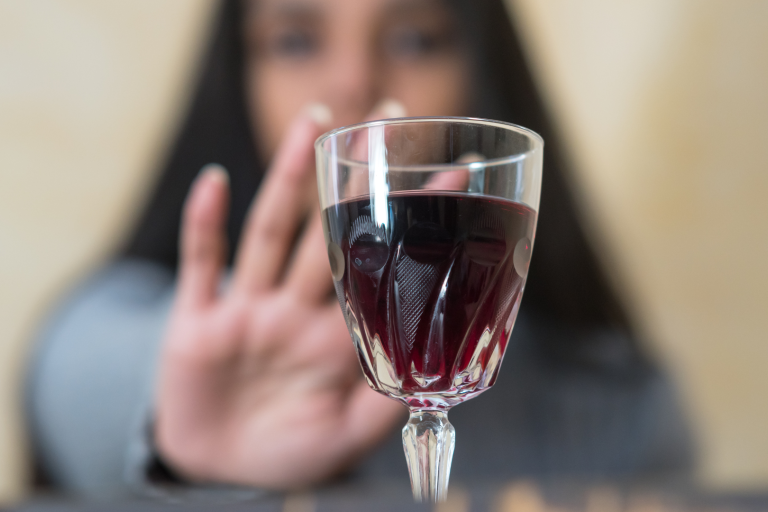 woman reaching for glass of wine