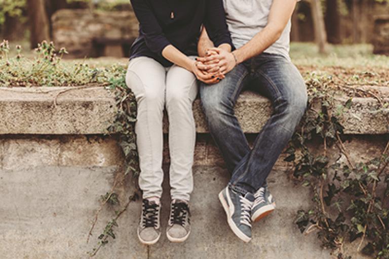 man and women sat on wall