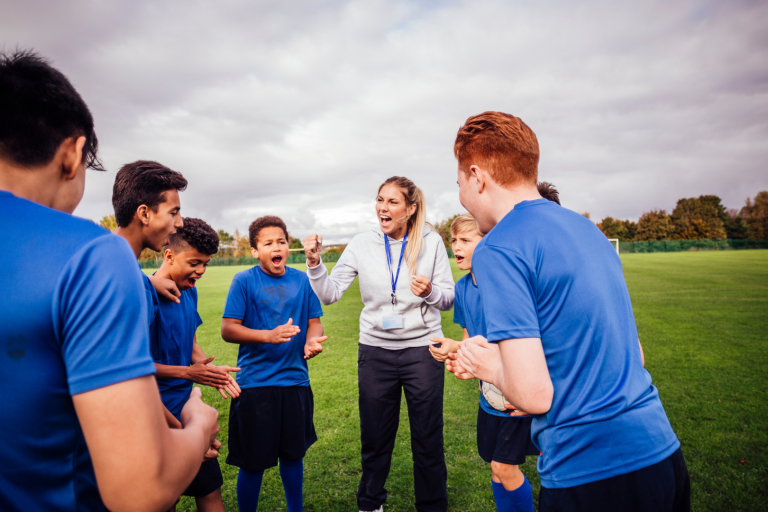 Teenage boys sports team grouped around coach