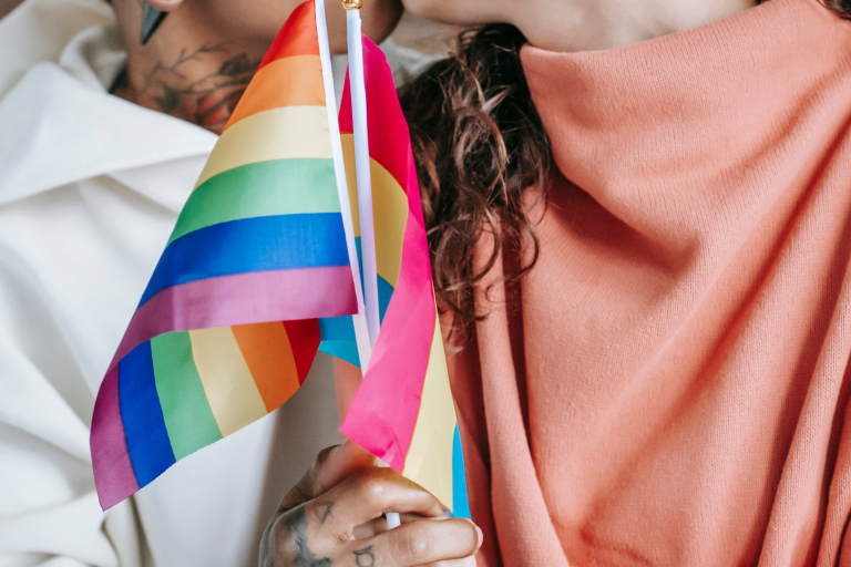 Two people holding pride flags