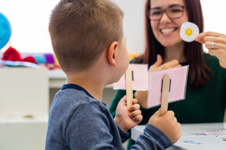 Toddler hold cards up with adult learning speech skills